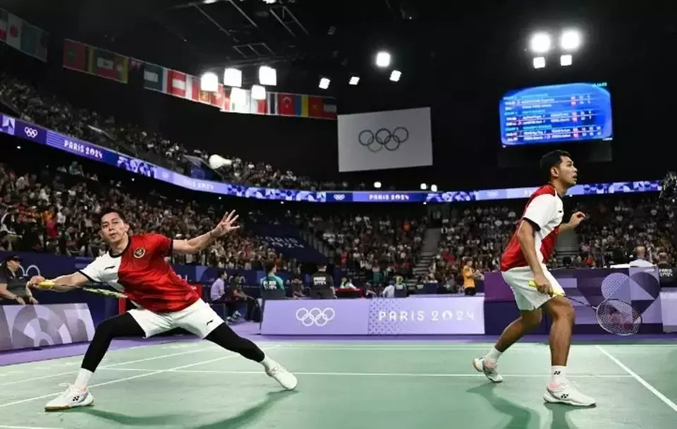 Ganda putra Indonesia Muhammad Rian Ardianto (kiri) dan Fajar Alfian mengembalikan kok ke arah lawannya ganda putra Jerman Mark Lamsfuss/Marvin Saidel pada babak penyisihan Grup C Olimpiade Paris 2024 di Porte De La Chapella Arena, Paris, Prancis, Sabtu 27 Juli 2024. 